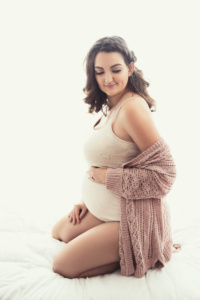 Intimate Studio Portrait of a Beautiful Pregnant Woman Posed in Bed