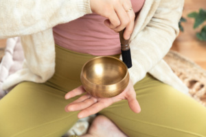 Young woman enjoying meditation with a Tibetan bowl sound bath